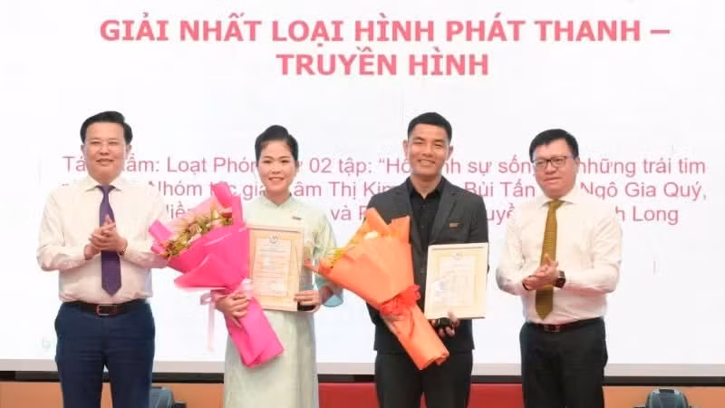 Le Quoc Minh, miembro del Comité Central del Partido Comunista de Vietnam, presidente-editor del periódico Nhan Dan (Pueblo), subjefe de la Comisión de Propaganda y Movilización de Masas del Comité Central y presidente de la Asociación de Periodistas de Vietnam, junto con Nguyen Thanh Hai, subsecretario permanente del Comité del Partido y presidente del Comité del Frente de la Patria de Vietnam de la provincia de Tay Ninh, entregan el primer premio a los autores galardonados.