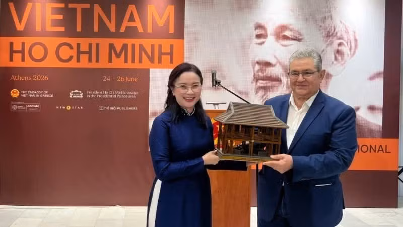 Le Thi Phuong, directora del Sitio de Reliquias del Presidente Ho Chi Minh, entrega una maqueta de la Casa sobre Pilotes del Presidente Ho Chi Minh a Dimitris Koutsoumpas, secretario general del Partido Comunista de Grecia. (Foto: Comité Organizador)