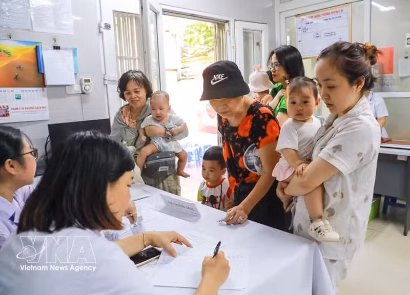 Las familias llevan a sus hijos a recibir vitamina A en la clínica del barrio de Bach Mai, en Hanói. (Foto: VNA)