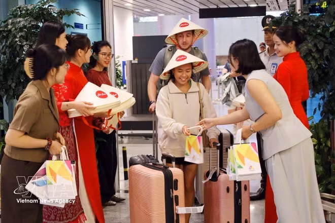 Los pasajeros de las dos nuevas rutas internacionales, Da Nang–Manila y Da Nang–Bali, reciben obsequios a su llegada a Da Nang. (Foto: VNA)