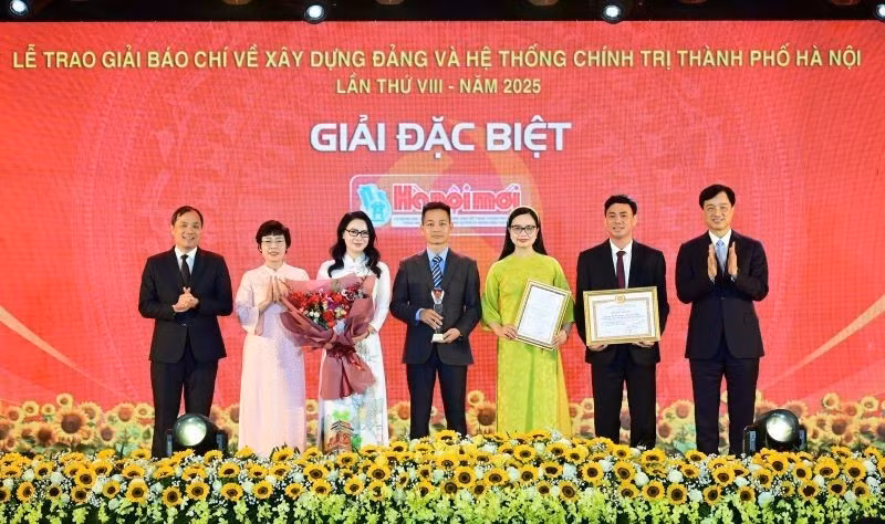 Nguyen Duy Ngoc, secretario del Comité del PCV en Hanói, y Hoang Trung Dung, subjefe permanente de la Comisión de Organización del Comité Central del Partido, entregan el Premio Especial a autores del periódico Hanoimoi.