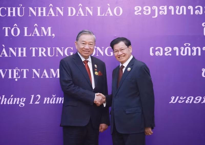El secretario general del PPRL y presidente de Laos, Thongloun Sisoulith, felicita al secretario general del PCV, To Lam, tras imponerle la Orden Nacional de Oro, la máxima distinción del Estado laosiano. (Foto: VNA)