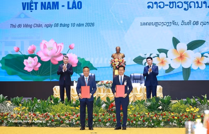 El primer ministro de Vietnam, Le Minh Hung, y su homólogo de Laos, Saleumxay Kommasith, presencian la entrega de certificados de inversión y la firma de acuerdos de cooperación en materia de inversión entre empresas de ambos países. (Foto: VNA)