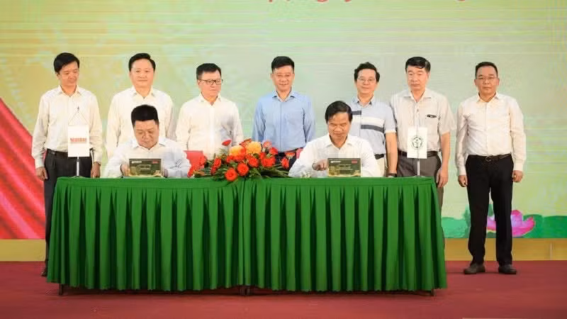 Que Dinh Nguyen, subjefe-editor del periódico Nhan Dan, y Dao Xuan Co, director del hospital Bach Mai firman el acuerdo de cooperación estratégica en representación de ambas entidades.