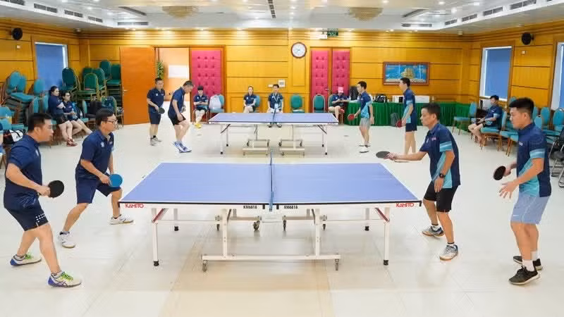 Atletas del periódico Nhan Dan y del hospital Bach Mai compiten en tenis de mesa en el marco del programa de intercambio deportivo entre ambas entidades.