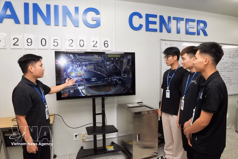 Un experto instruye a los trabajadores en la compañía de tecnología Amkor Vietnam Co., Ltd., situada en el Parque Industrial Yen Phong, en la provincia de Bac Ninh. (Foto: VNA)