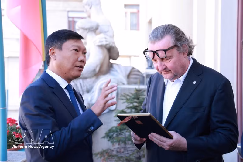 El vicepresidente del Comité Popular de Hanoi, Do Anh Tuan (izquierda), obsequia un regalo al vicealcalde de Praga, Petr Hlavacek. (Foto: VNA)