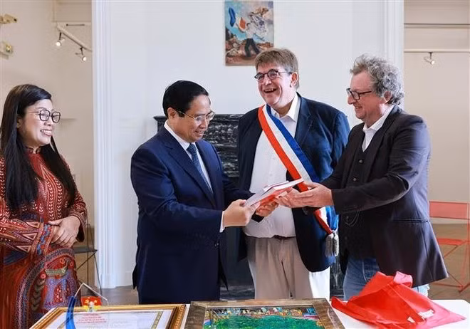 Los representantes del Museo de Historia Viva de Montreuil regalan al primer ministro Pham Minh Chinh y su esposa libros sobre el Presidente Ho Chi Minh (Foto. VNA)