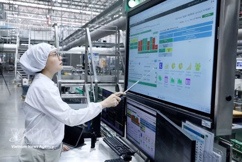 Los trabajadores de la fábrica Bong Sen del Grupo Nestlé Vietnam operan la línea de producción mediante un panel de control automatizado. (Foto: VNA)