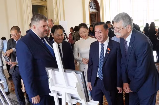 El presidente de la Asamblea Nacional Húngara, Kover Laszlo (primero, desde la derecha), y los delegados visitan la exposición fotográfica. (Foto: VNA)