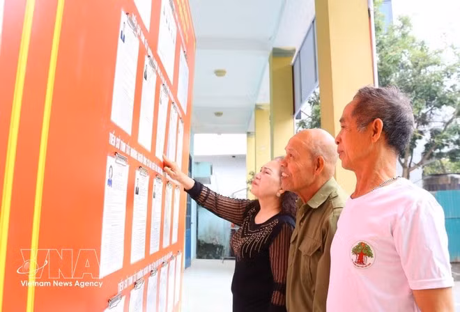 Los votantes de la comuna de O Dien, Hanoi, miran las listas de candidatos para la XVI Legislatura del Parlamento y los Consejos del Pueblo en todos los niveles para el mandato 2026-2031. (Foto: VNA)