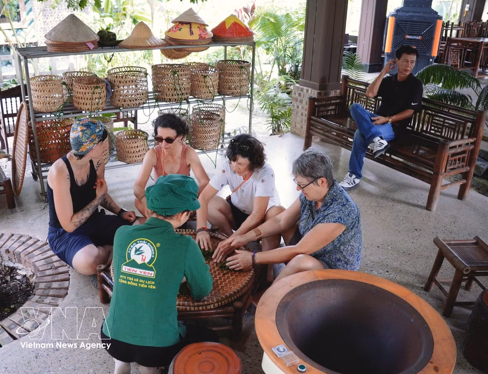 Turistas internacionales disfrutan de la elaboración tradicional de té artesanal en la Cooperativa de Té y Turismo Comunitario Tien Yen, en la comuna de Tan Cuong. (Foto: VNA)