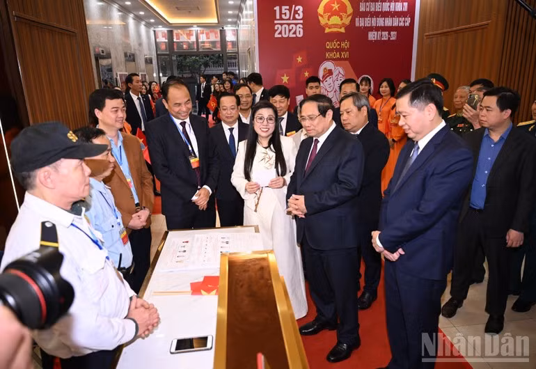 El primer ministro de Vietnam, Pham Minh Chinh, y su cónyuge con votantes en el colegio electoral número 21, ubicado en el barrio de Tay Ho, en Hanói.
