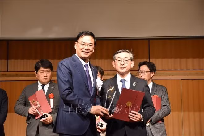 El embajador de Vietnam en Japón, Pham Quang Hieu, entrega una carta de reconocimiento y una copa conmemorativa al director de la empresa Corps, Kato Ryo. (Foto: VNA)