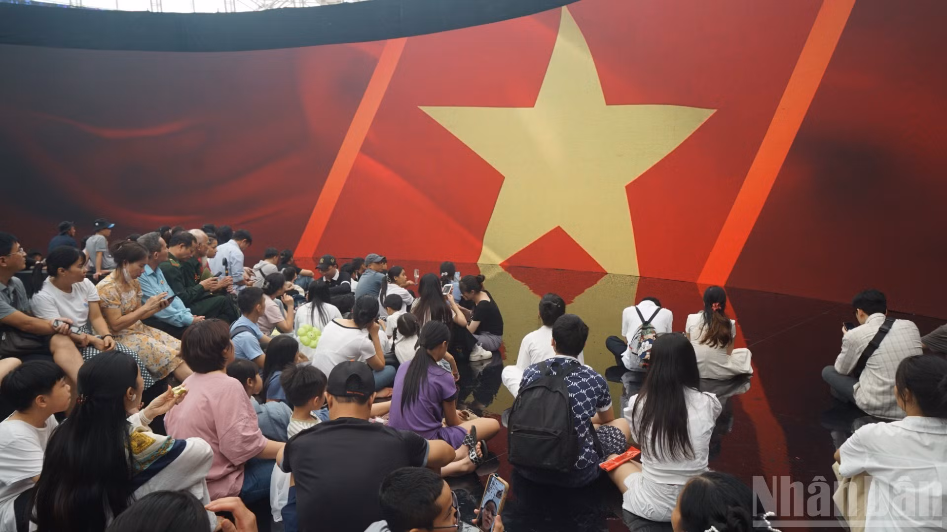 Los visitantes observan con atención una pantalla LED gigante que recrea etapas de la historia revolucionaria con imágenes y sonido vívidos.