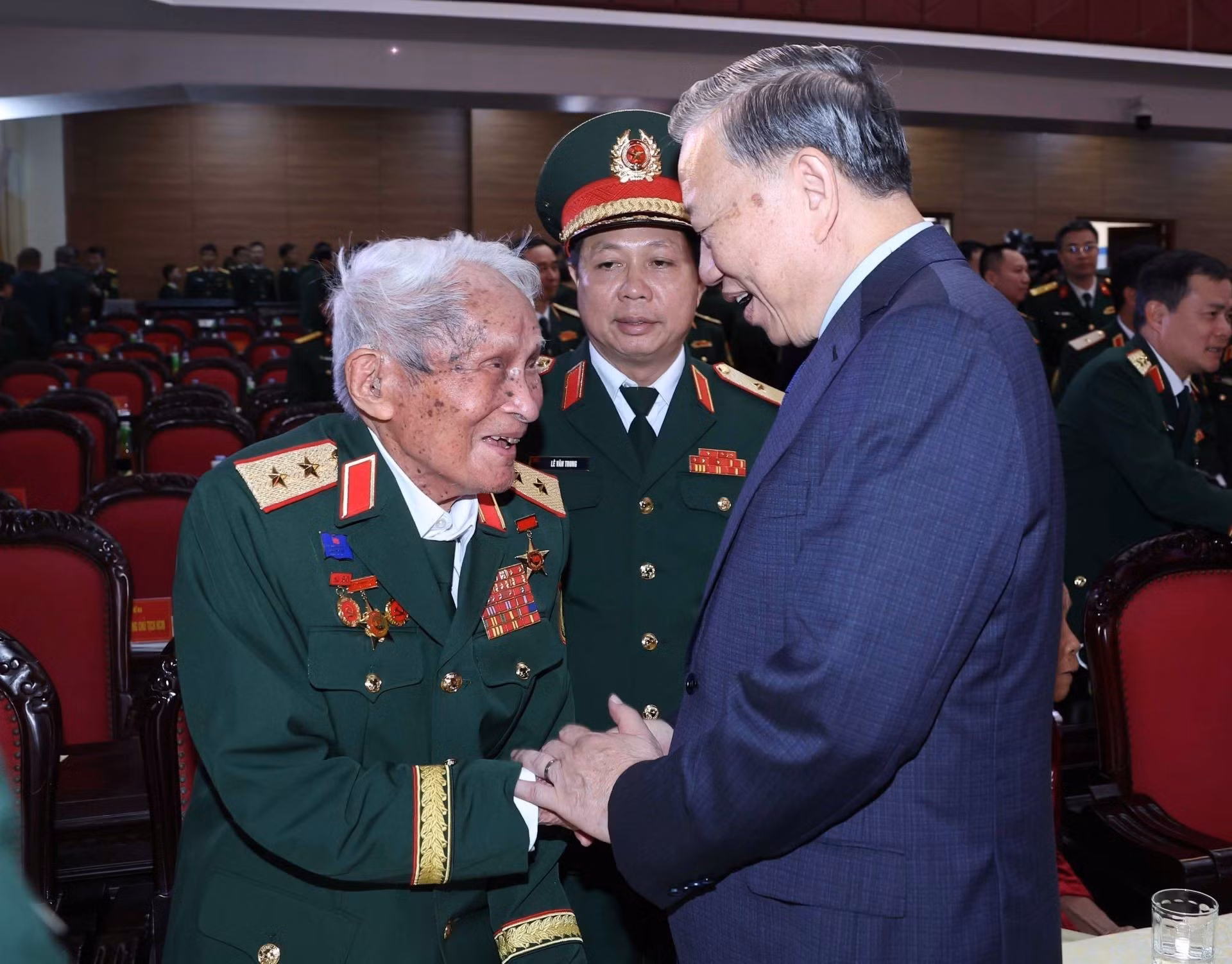 El secretario general del PCV, To Lam, saluda al teniente general Nguyen Quoc Thuoc, excomandante de la Zona Militar 4.