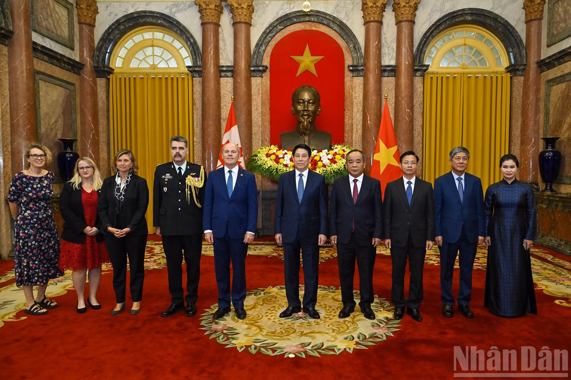 El presidente de Vietnam, Luong Cuong, posa junto al embajador de Canadá, James Nickel, y otros delegados en la cita.