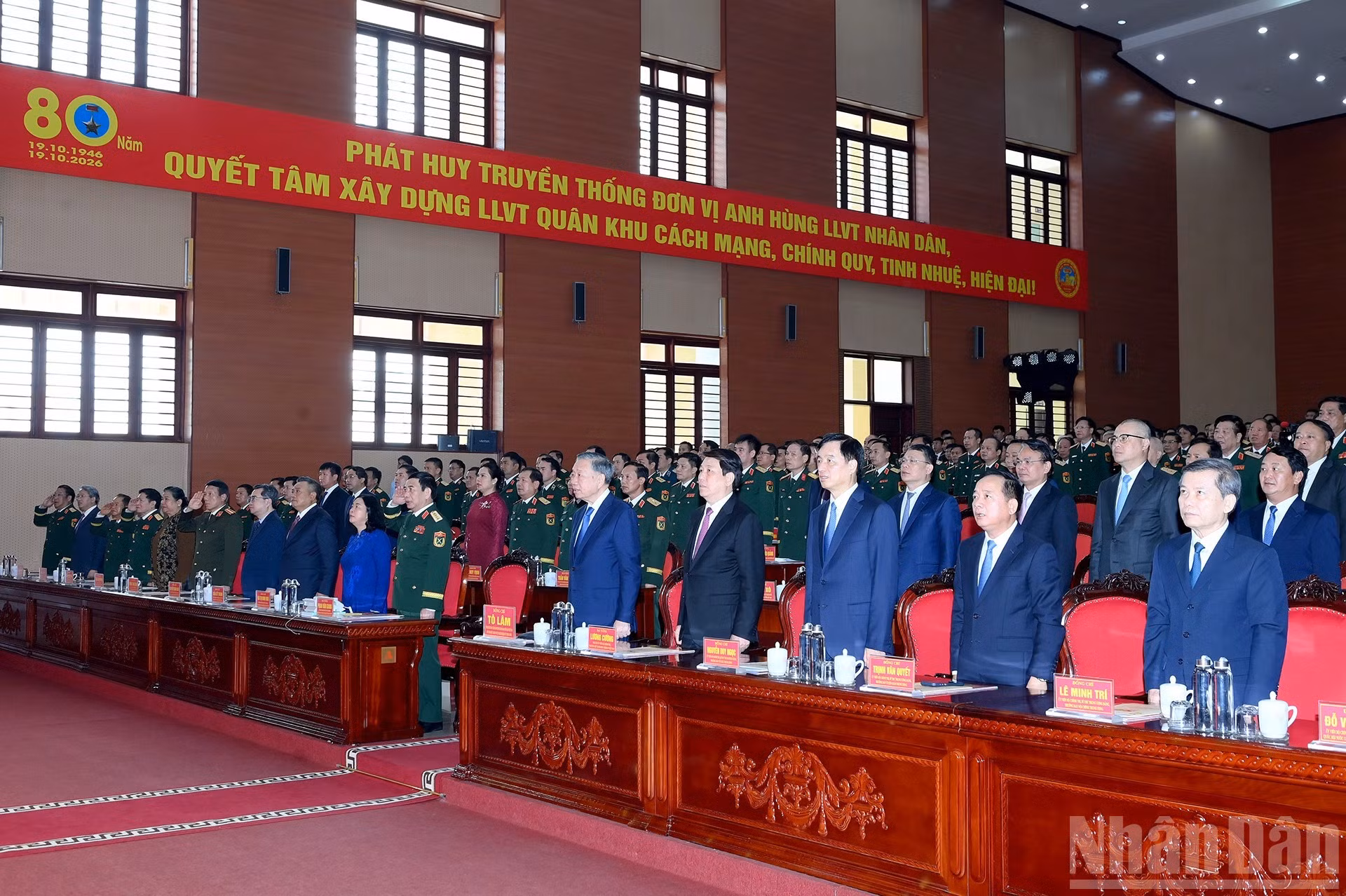 Los asistentes realizan el acto de saludo a la bandera nacional.