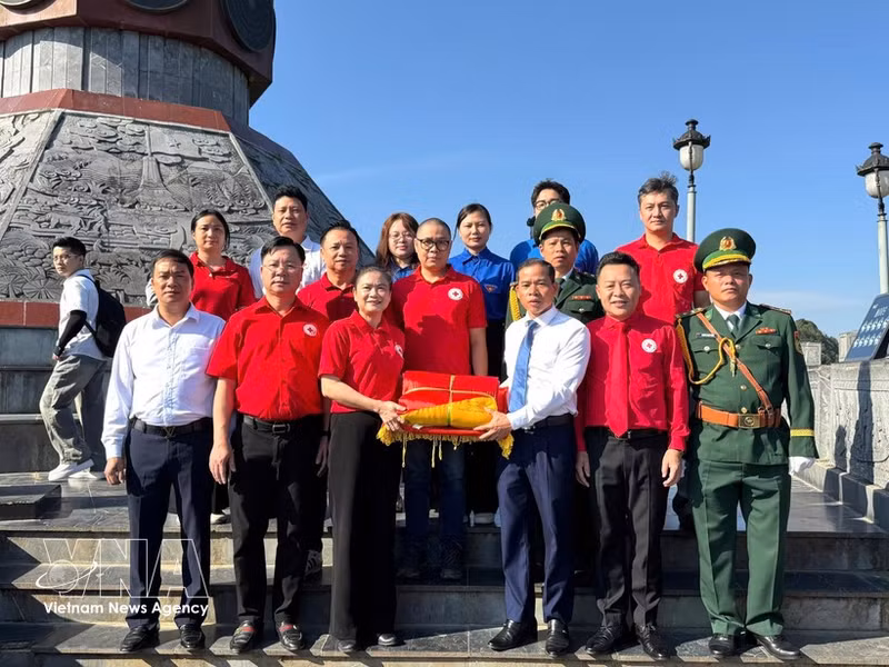 Delegados y turistas en la ceremonia de izamiento de la bandera (Foto: VNA)