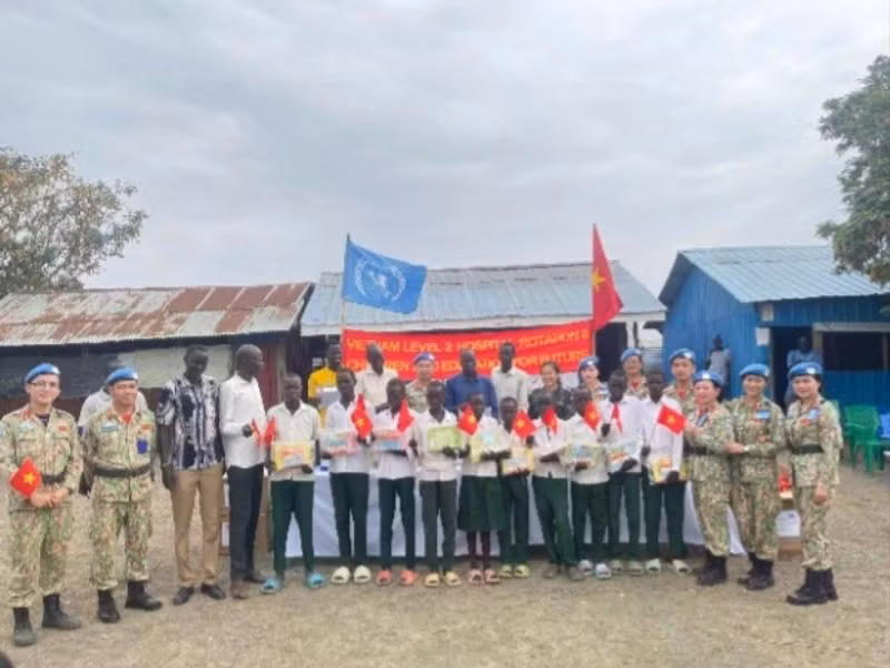 El grupo de trabajo del Hospital de Campaña de segundo nivel número 6 de Vietnam entrega obsequios a alumnos de la Escuela Primaria Banpa, Sudán del Sur. 