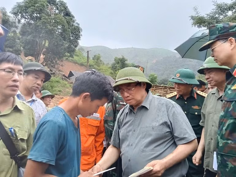 El premier Pham Minh Chinh entrega regalo a las personas afectadas por desastres naturales.