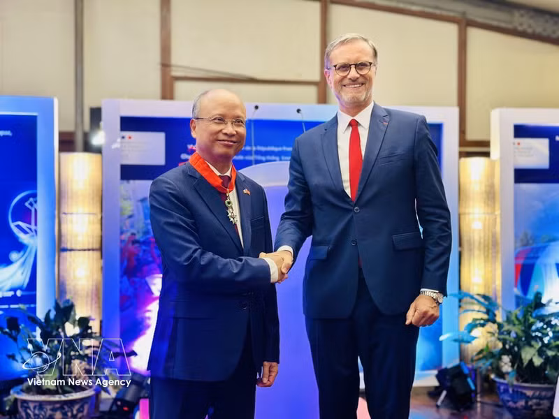 El embajador de Francia en Vietnam, Olivier Brochet, entrega la Legión de Honor al exembajador de Vietnam en Francia, Dinh Toan Thang (Fuente: VNA)