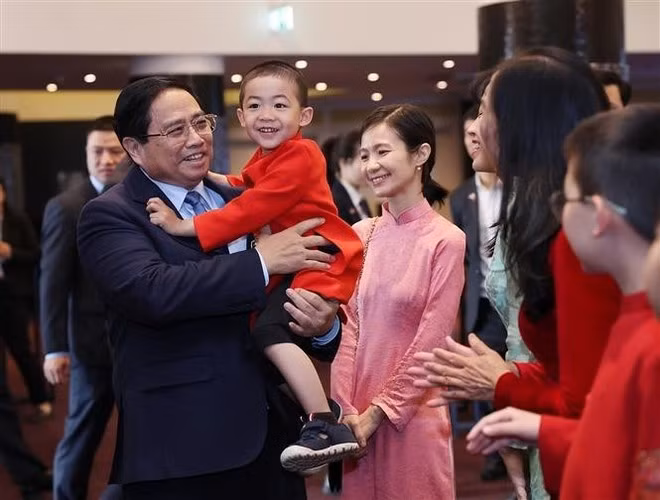El primer ministro Pham Minh Chinh y residentes connacionales en Estonia. (Fuente: VNA)