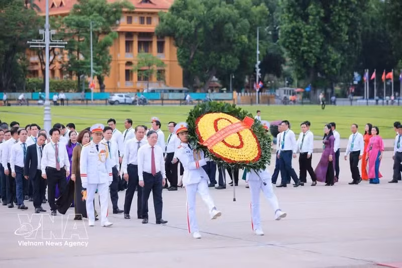Delegados depositan ofrendas florales y rinden homenaje al Presidente Ho Chi Minh en su mausoleo. (Fuente: VNA)