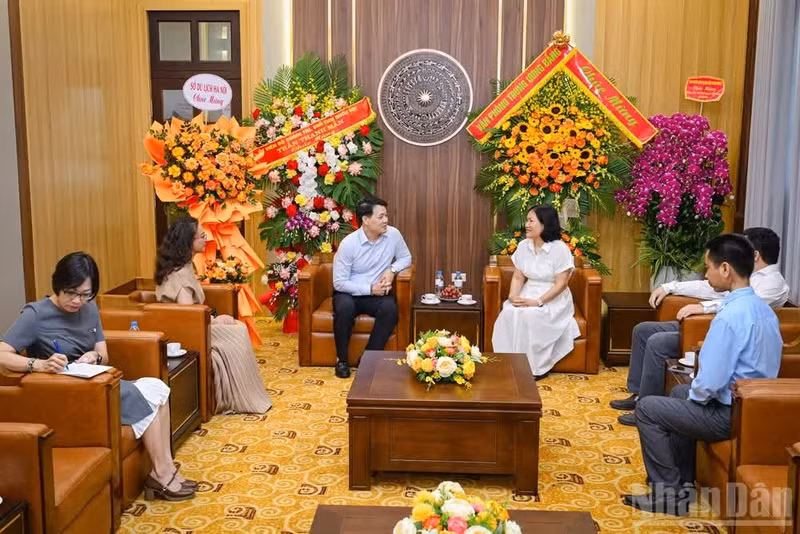 Kieu Thanh Huong, subdirectora del Departamento de Gestión de Corresponsales Permanentes de Nhan Dan, recibe al subdirector del Departamento de Turismo de Hanói, Nguyen Tran Quang.