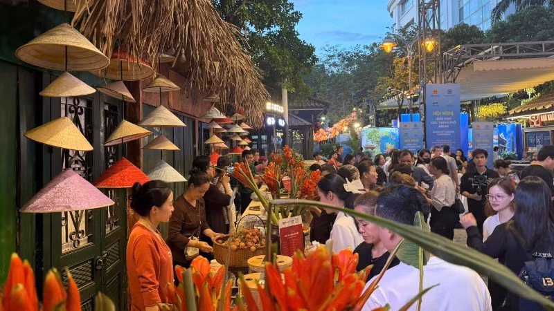Numerosos delegados nacionales e internacionales exploran el espacio gastronómico en la Calle del Libro de Hanói.