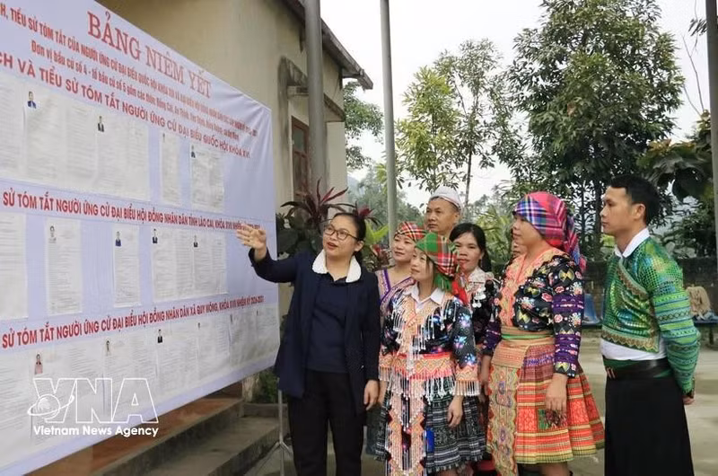 La jefa del Equipo de Encuestas No. 5 en la comuna de Quy Mong, provincia de Lao Cai, presenta las listas de candidatos a los residentes locales. (Foto: VNA)