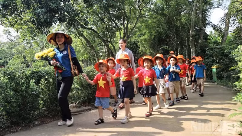 Los pequeños son guiados por sus maestras para visitar la aldea paterna del Presidente Ho Chi Minh.
