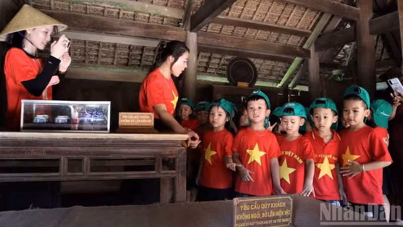 Los niños observan objetos en el Área Especial de Reliquias Nacionales de Kim Lien.