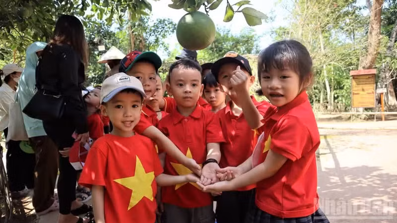 Los niños junto al árbol de pomelo frente a la casa del Tío Ho.