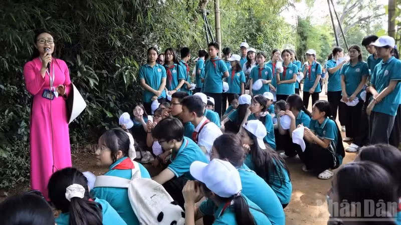 Estudiantes destacados de la escuela secundaria Le Loi, en el barrio de Thanh Vinh, en Nghe An, visitan el sitio histórico.