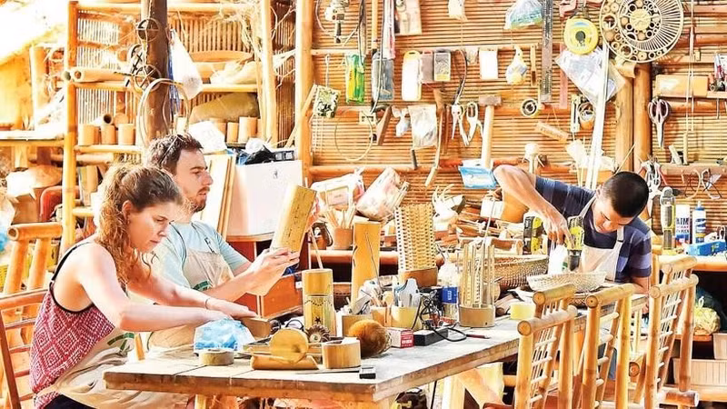 Turistas elaboran sus propios recuerdos de bambú en un taller artesanal de Da Nang. (Fuente: nhandan.vn)