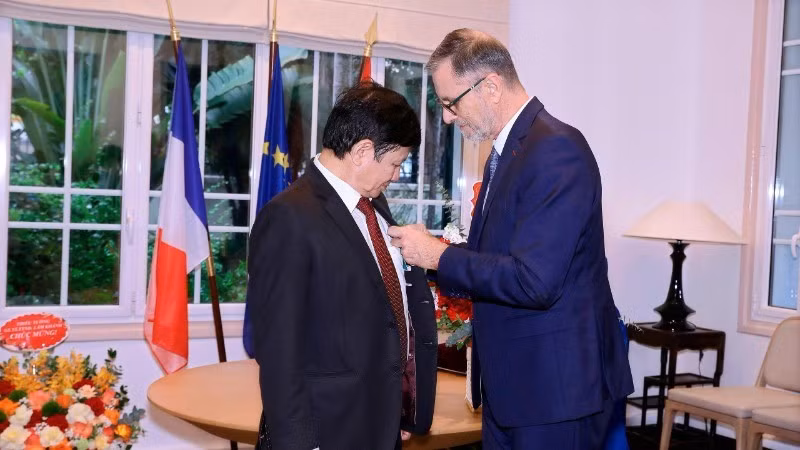 El embajador de Francia en Vietnam, Olivier Brochet, entrega la Orden Nacional del Mérito al profesor y doctor Le Danh Tuyen.