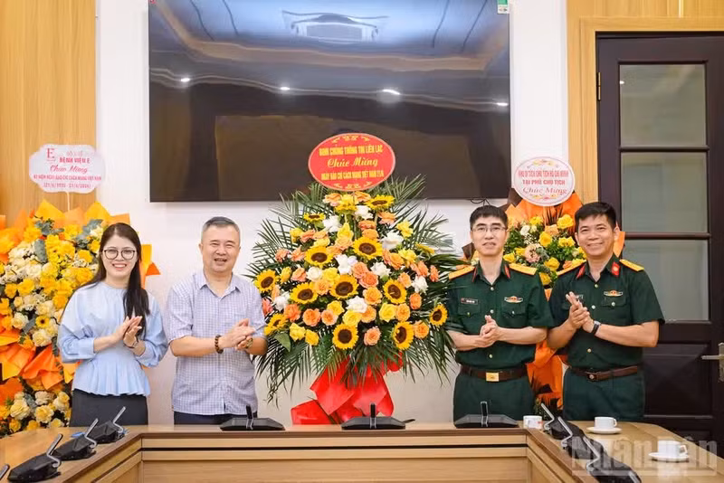El teniente coronel Tran Quoc Thai, subdirector del Departamento de Propaganda y Educación del Cuerpo de Comunicaciones del Ministerio de Defensa Nacional, felicita al periódico Nhan Dan.