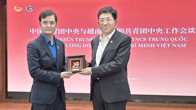 Bui Quang Huy entrega a A Dong un relieve representativo del XIII Congreso Nacional de la Unión de Jóvenes Comunista Ho Chi Minh. 
