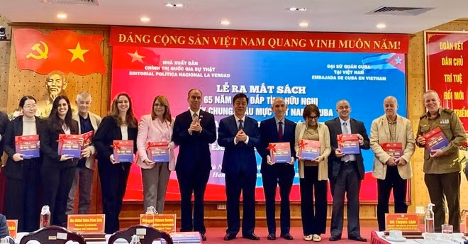 El embajador de Cuba en Vietnam, Rogelio Polanco Fuentes, y el director general y editor en jefe de la Editorial Nacional de Política Su That (La Verdad), Vu Trong Lam, entregan libros a representantes de agencias. (Foto: VNA)