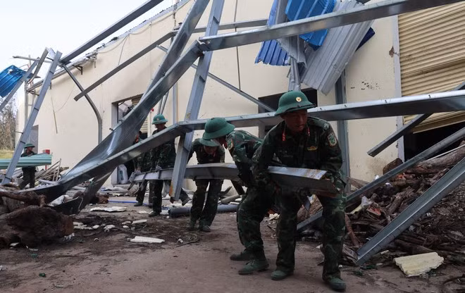 Soldados de la División 31, Región Militar 5, ayudan a empresas de la Zona Económica de Nhon Hoi, en la provincia de Gia Lai, a limpiar las fábricas dañadas por las recientes tormentas (Foto: VNA)