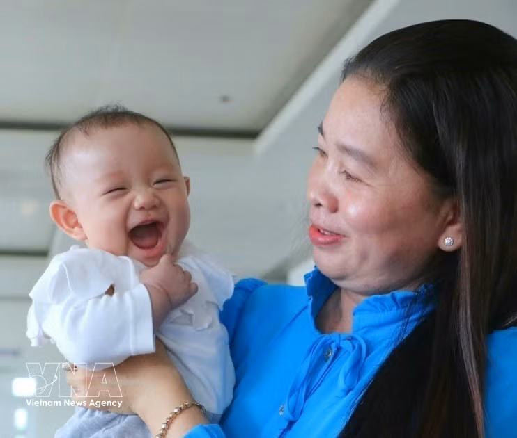 Una niña acompaña a su madre en la ceremonia de reconocimiento a familias ejemplares con dos hijas, organizada por la provincia de Hau Giang el 5 de enero de 2023. (Foto: VNA)