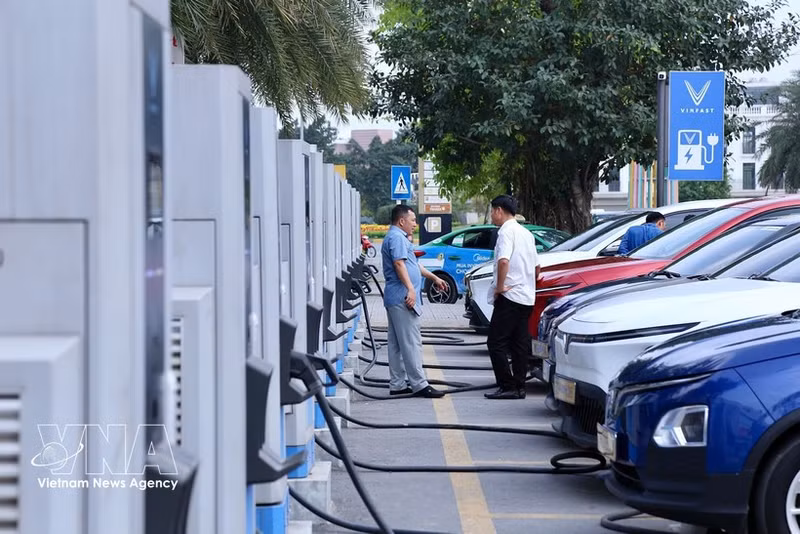 Varias personas cargan sus vehículos eléctricos en una estación de carga en el oeste de Hanoi. (Foto ilustrativa: VNA)
