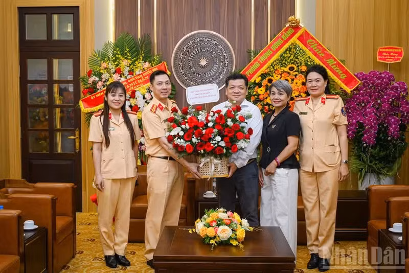 El subdirector de la Oficina de Nhan Dan, Phan Bang Son, y el coronel Pham Viet Cong, subdirector del Departamento de Policía de Tránsito del Ministerio de Seguridad Pública, se toman una foto durante la visita de felicitación.