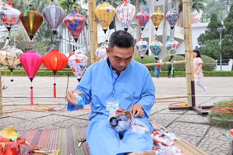 Un artesano elabora una linterna de Hoi An. Un artesano elabora una linterna de Hoi An.