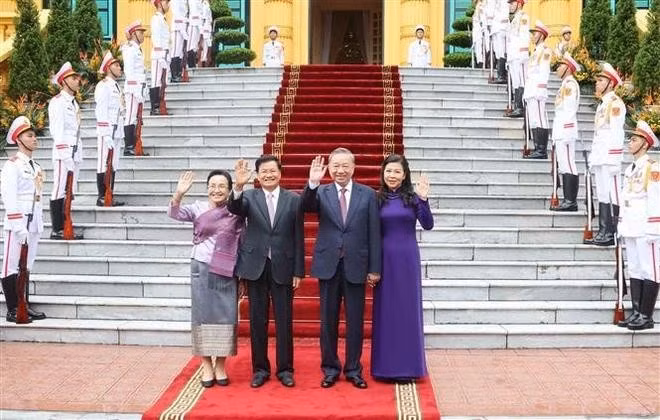 El secretario general del Partido Comunista y presidente de Laos, To Lam, y su esposa ofrecieron una ceremonia de bienvenida con alfombra roja para el secretario general del Comité Central del Partido Popular Revolucionario y presidente de Laos, Thongloun Sisoulith, y su esposa, en Hanói. (Foto: VNA)