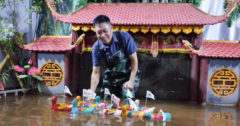 El artista Phan Thanh Liem y su escenario de marionetas acuáticas en miniatura.