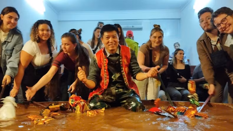 Los turistas extranjeros disfrutan del espectáculo de títeres de agua en la casa del artista Phan Thanh Liem.