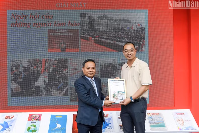 El vicepresidente-editor de Nhan Dan, Dinh Nhu Hoan entrega el primer premio.