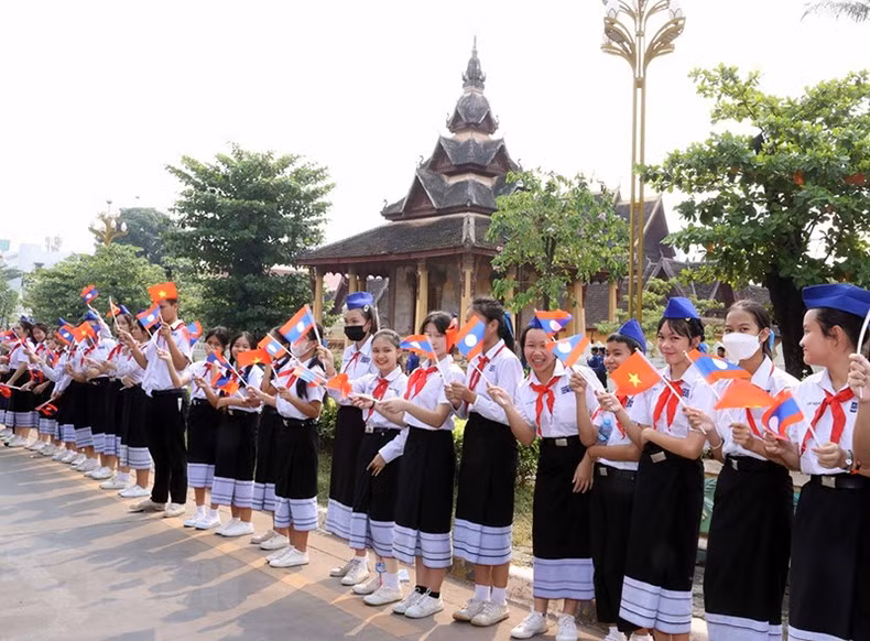 Niños en Vientián dan la bienvenida al mandatario vietnamita.